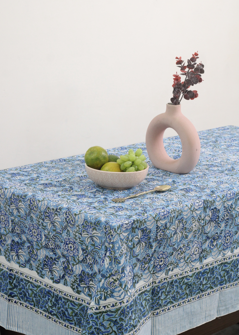 Blue floral table cloth with vase and fruits