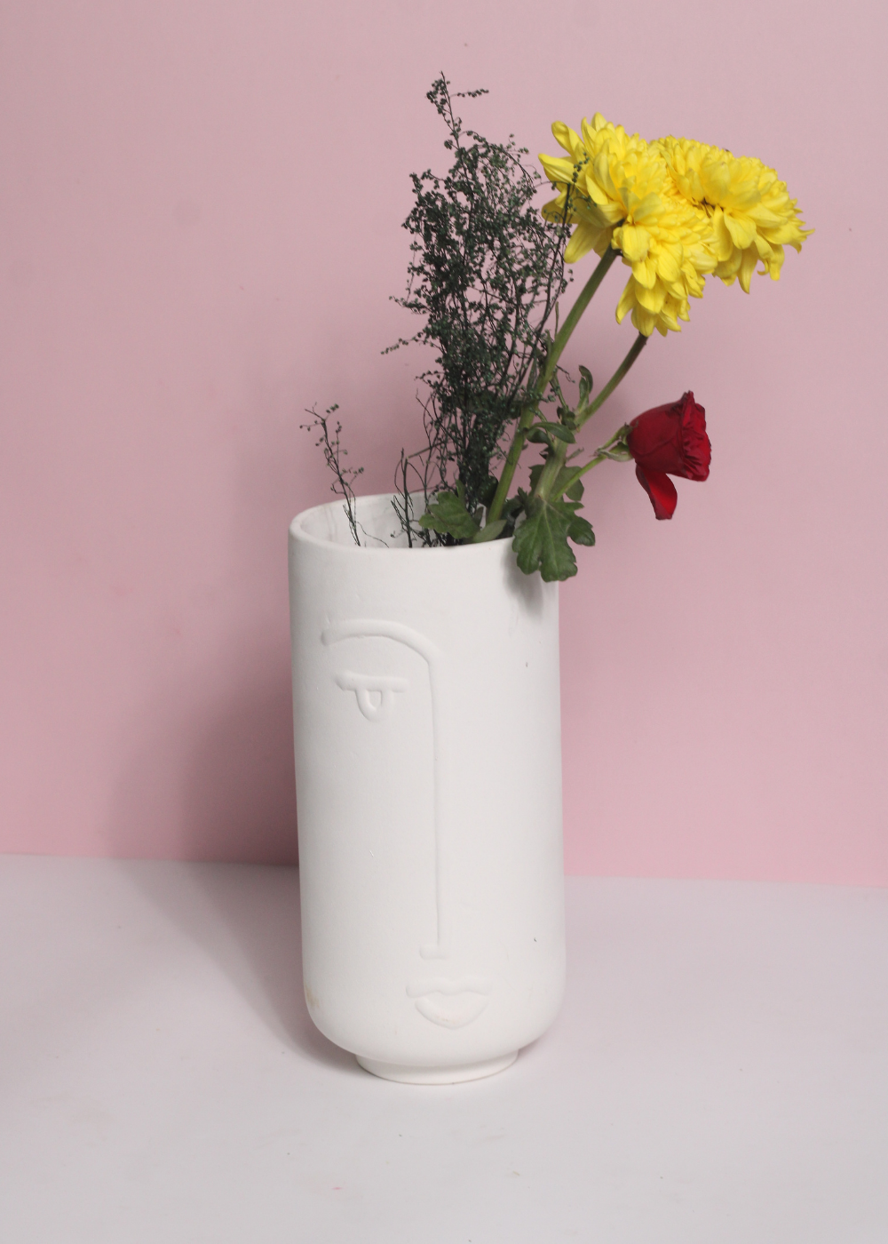 Unique design face vase with red and yelllow flowers