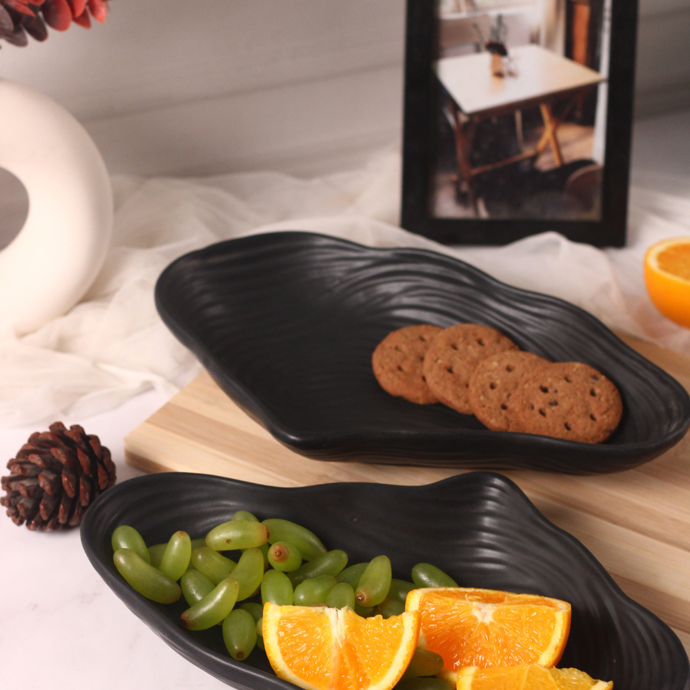 Two black mistif bowl with fruits and biscuits
