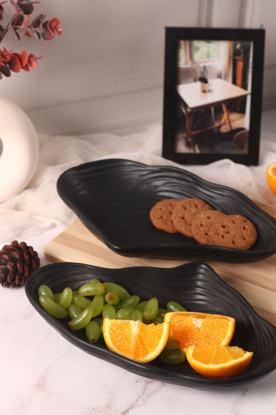 Two black mistif bowl with fruits and biscuits