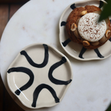 Two black and white handmade dessert plate with dessert
