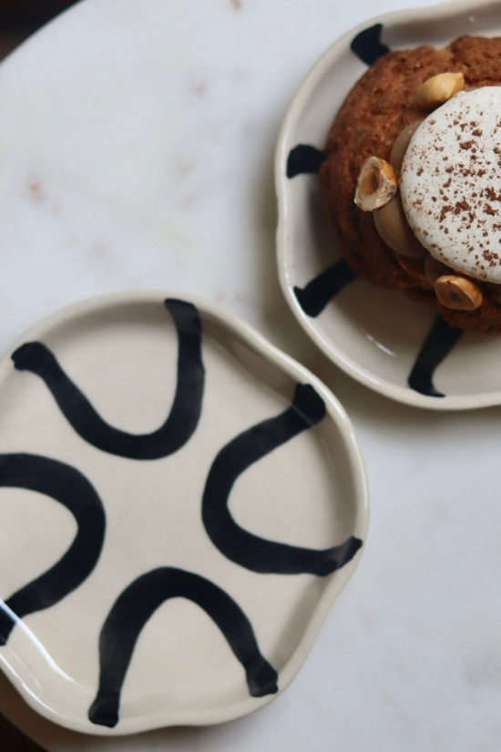 Two black and white handmade dessert plate with dessert