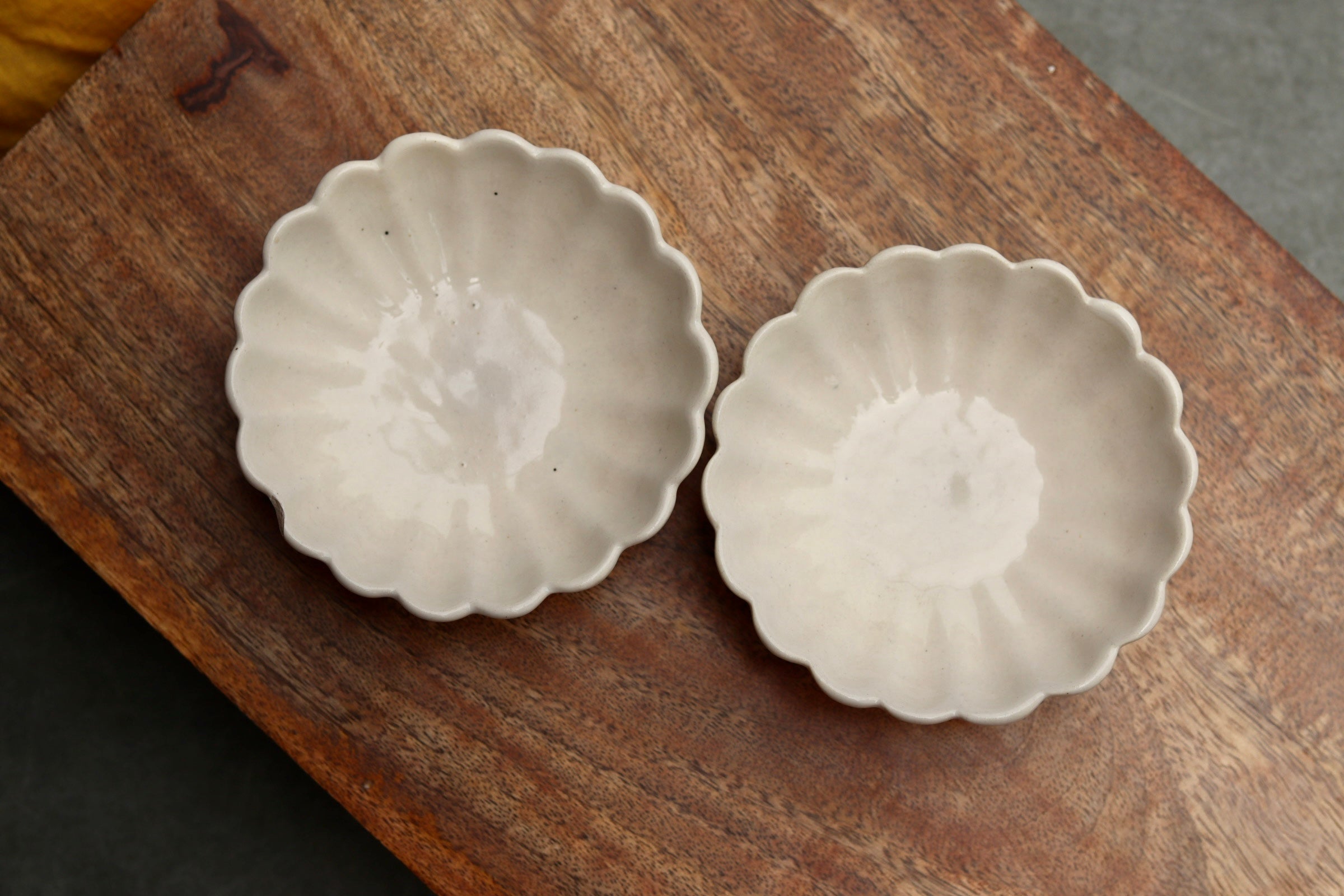 Two handmade ceramic ice cream bowls on wooden surface