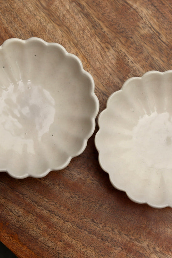 Two handmade ceramic ice cream bowls on wooden surface