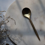 Gold dinner spoon on marble 
