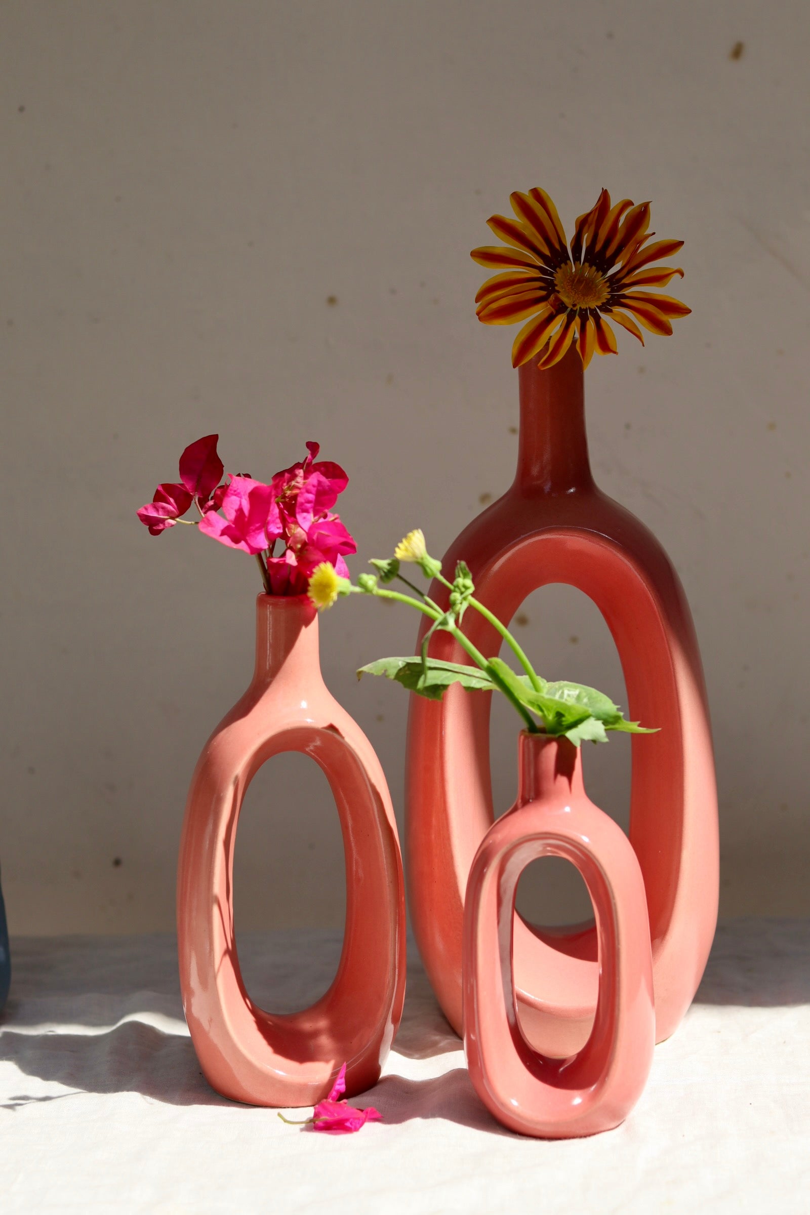 Three pink contour vases with flowers