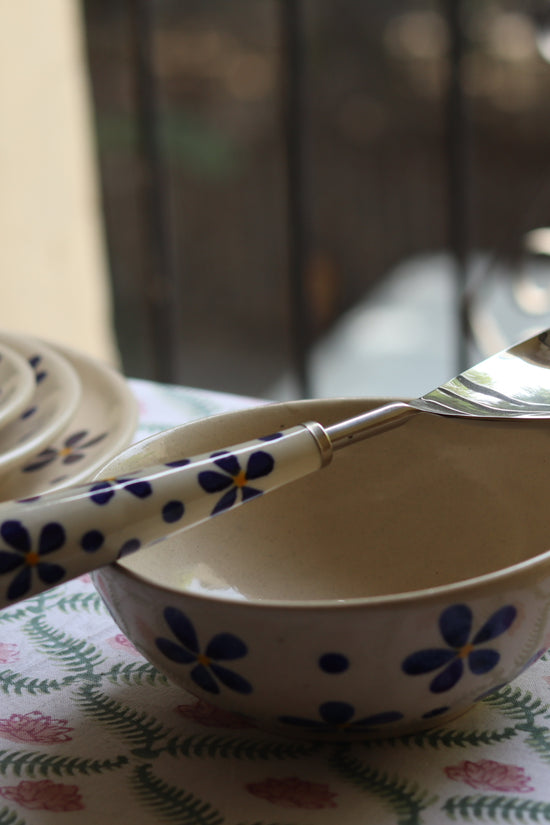 A floral design Serving spoon Laying on a bowl