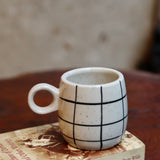 Black checkered coffee mug on a book