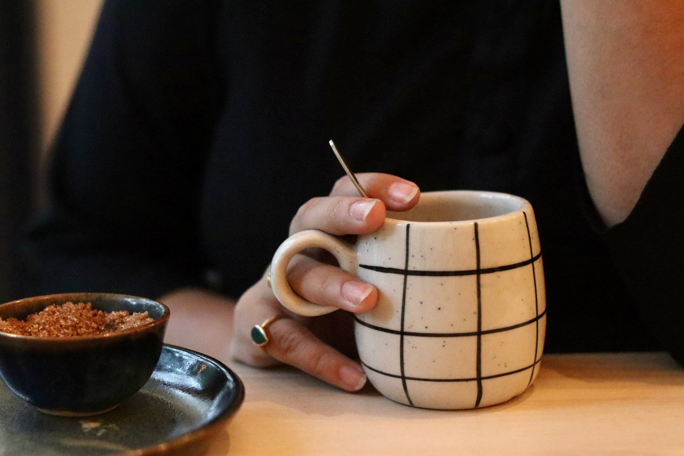 Black checkered coffee mug in a hand