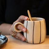 Black lined coffee mug in a hand