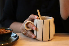 Black lined coffee mug in a hand