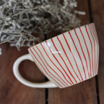 Red lined coffee mug on wooden surface 