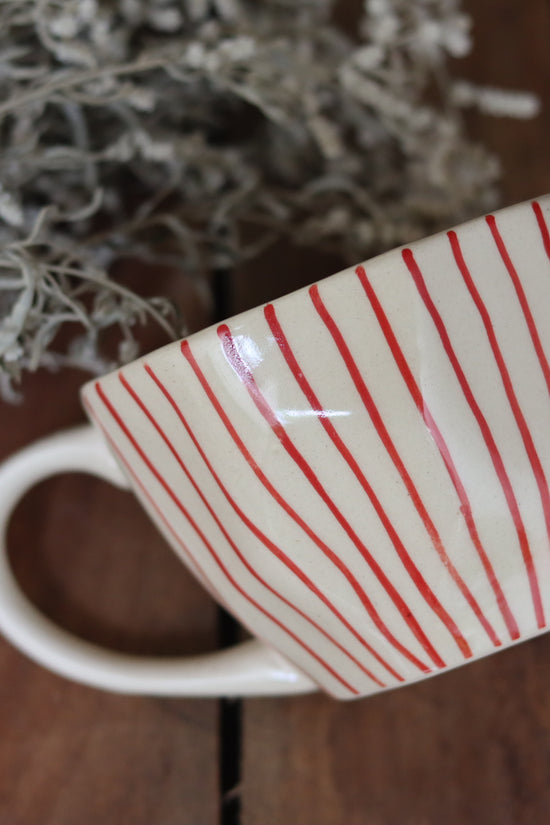 Red lined coffee mug on wooden surface 
