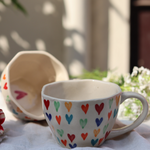 Two multicolor coffee mugs With heart design