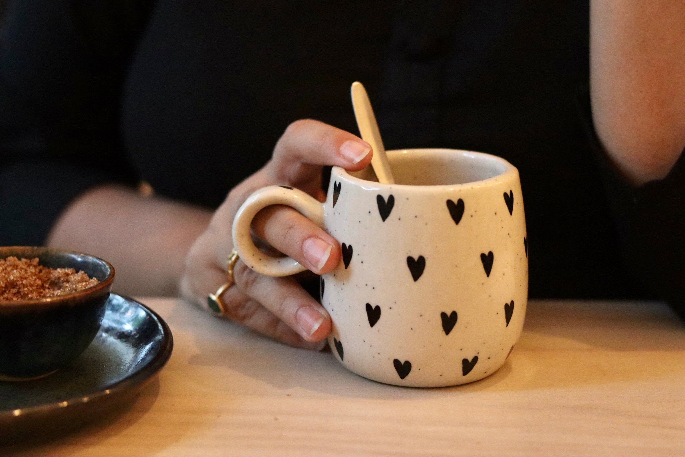 Black heart cuddle mug in a hand