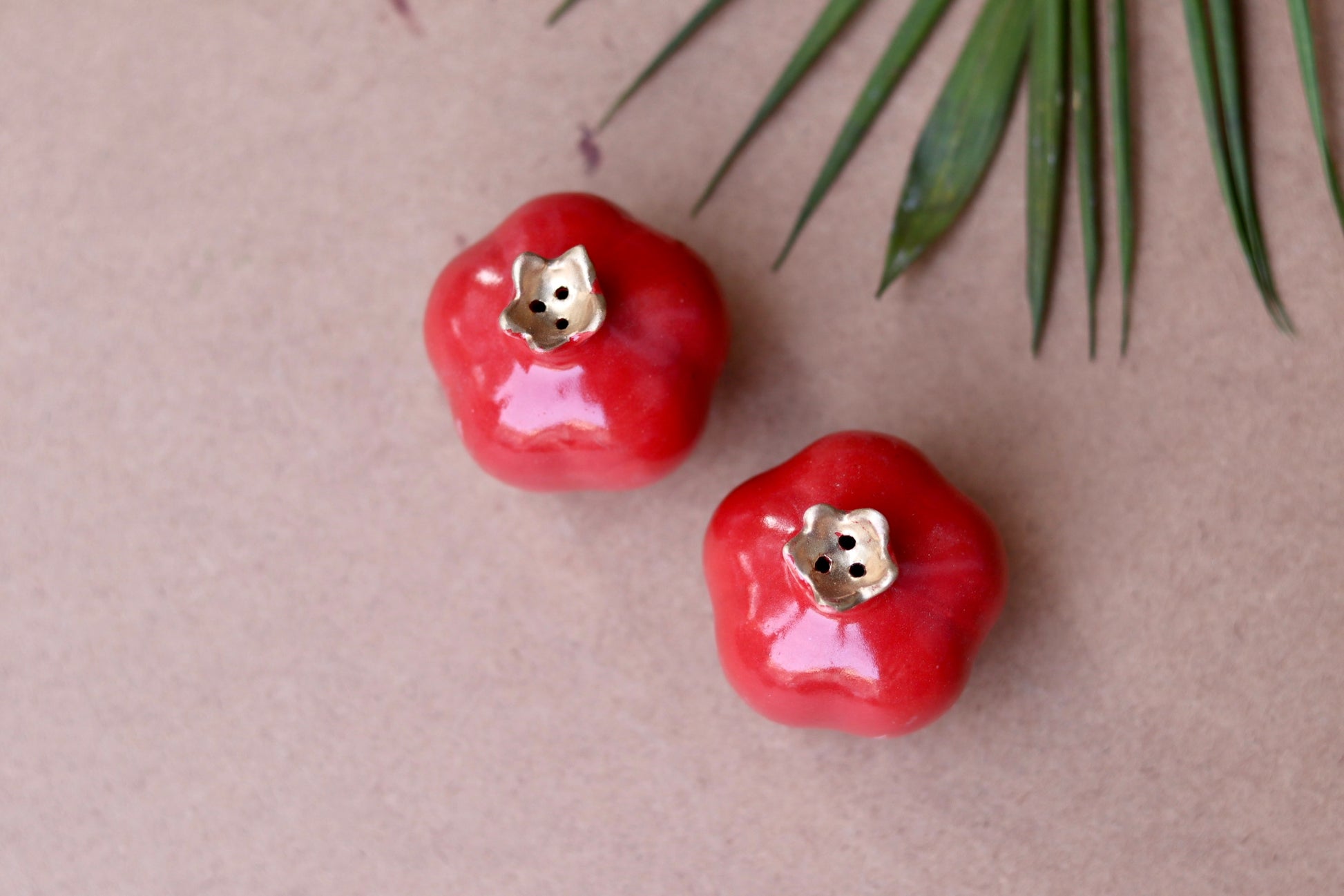 Two red anar shaped salt and pepper shakers