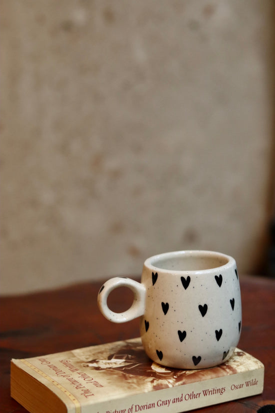 Black heart cuddle mug on a book