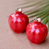 Two red anar salt and pepper shakers
