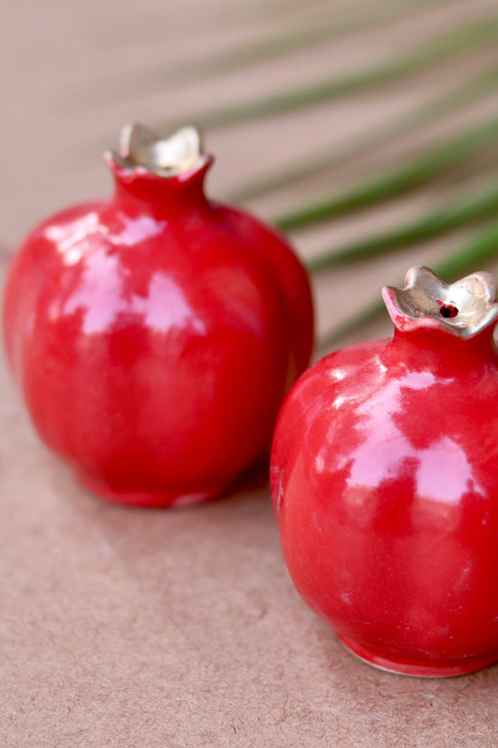 Two red anar salt and pepper shakers