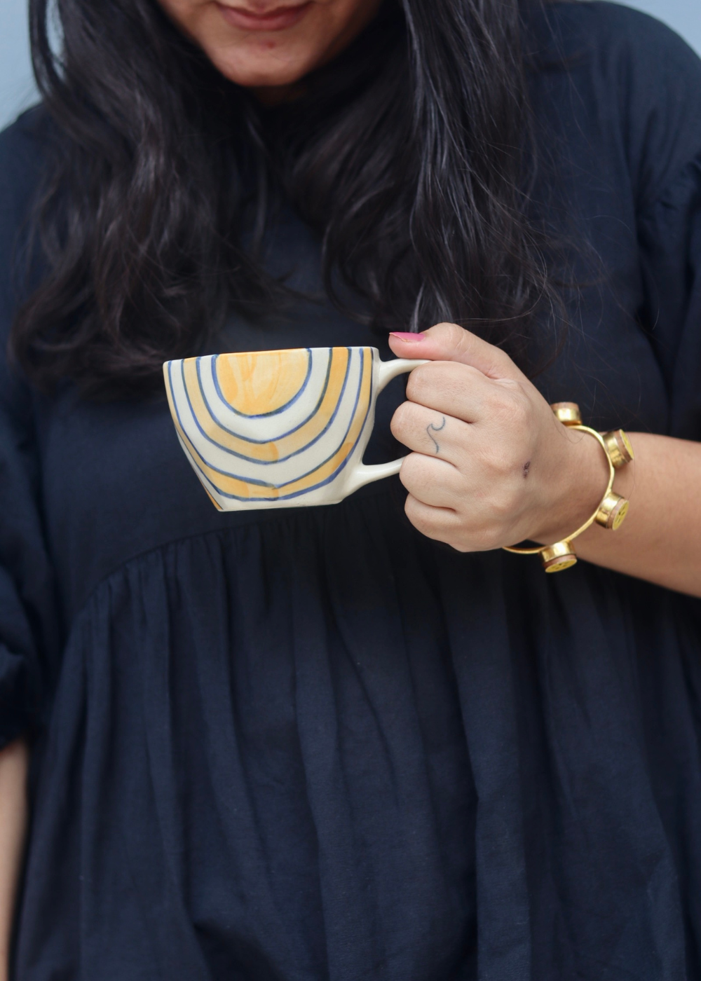 Mustard abstract coffee mug in hand 