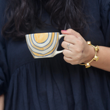 Mustard abstract coffee mug in hand 