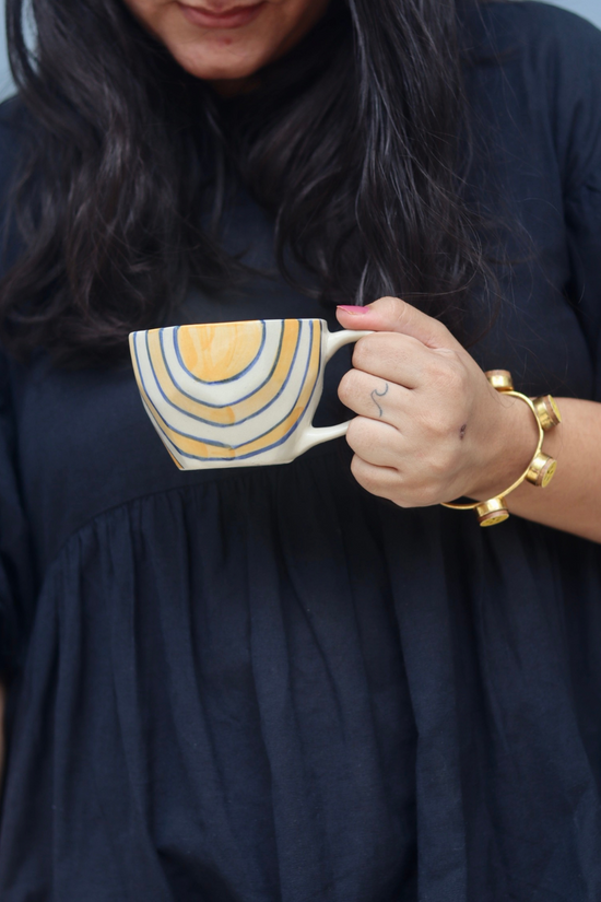 Mustard abstract coffee mug in hand 